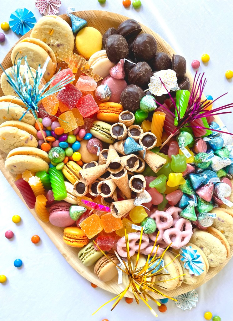 Whimsical candy and chocolate board styled with florals, designed for parties in Riverside and Western Springs