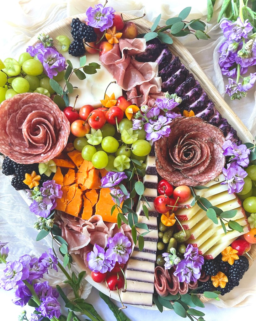 Luxury medium charcuterie board with seasonal fruits, cured meats, and fresh greenery, styled for events in Hinsdale and Oak Park