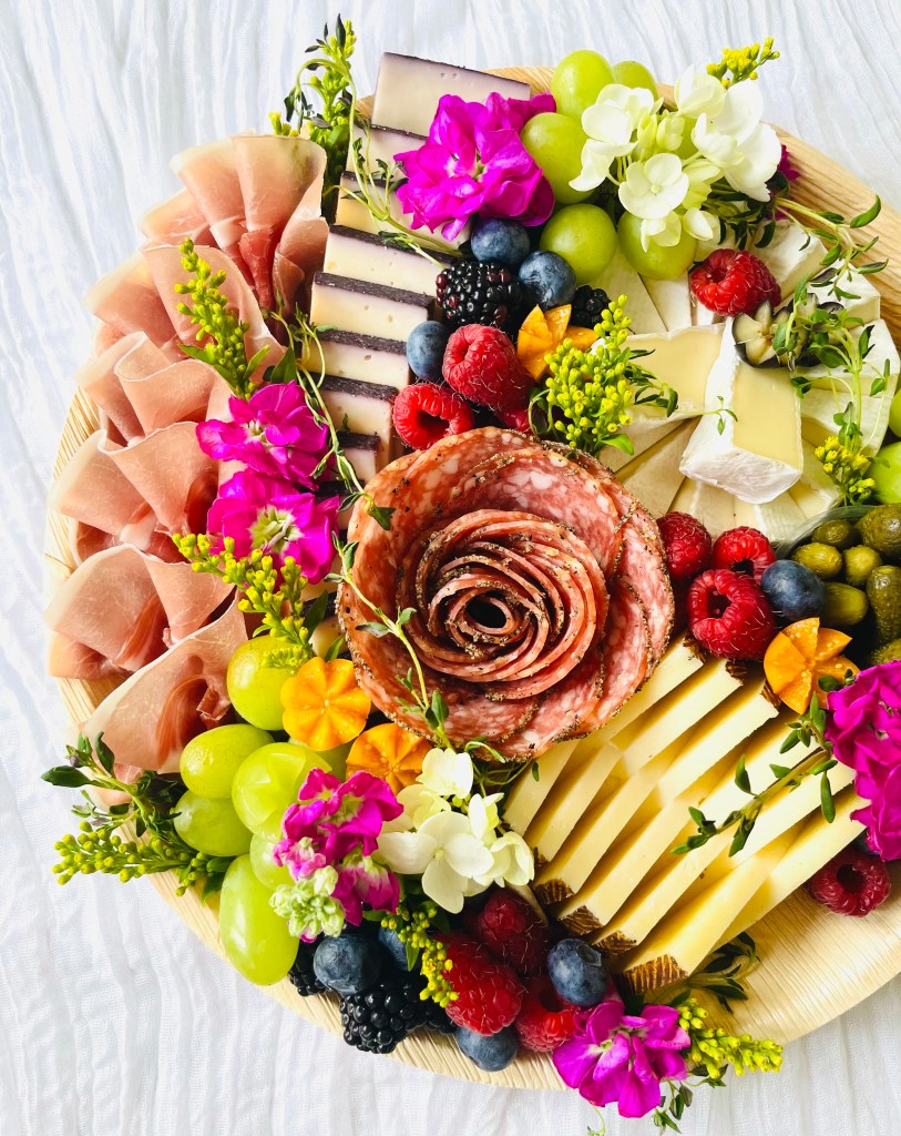 Botanically inspired small charcuterie board with artisan cheeses, meats, and florals for gatherings in La Grange and Western Springs.