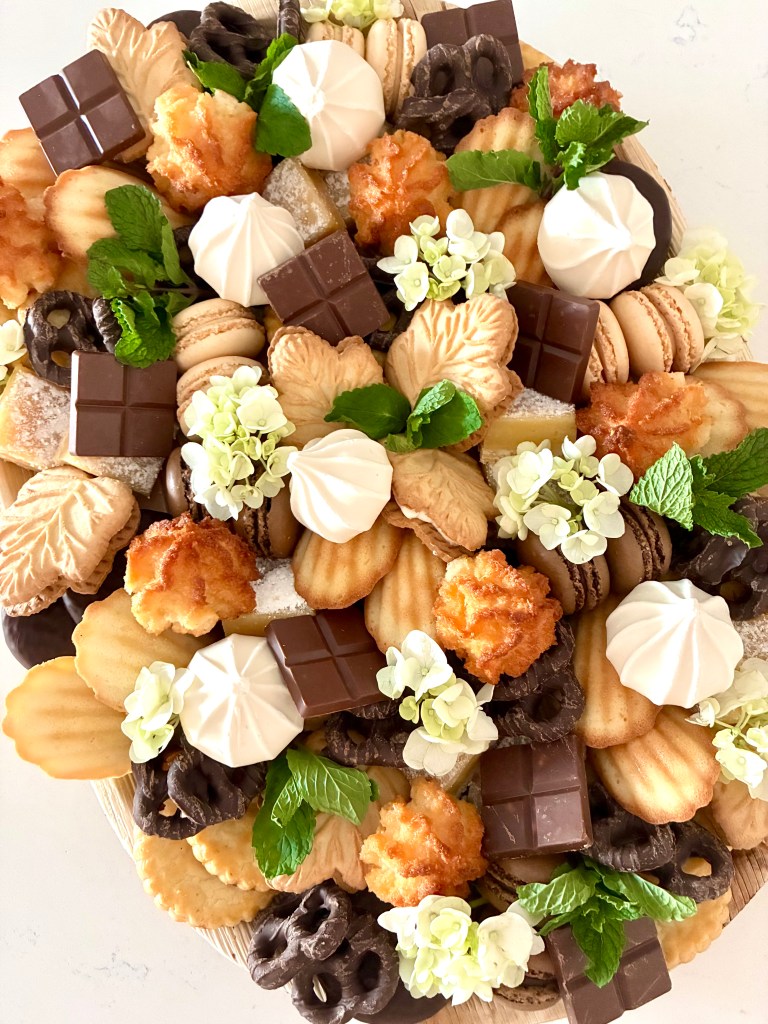 Elegant sweets board with cookies and pastries accented with greenery, available for events in La Grange and Oak Brook