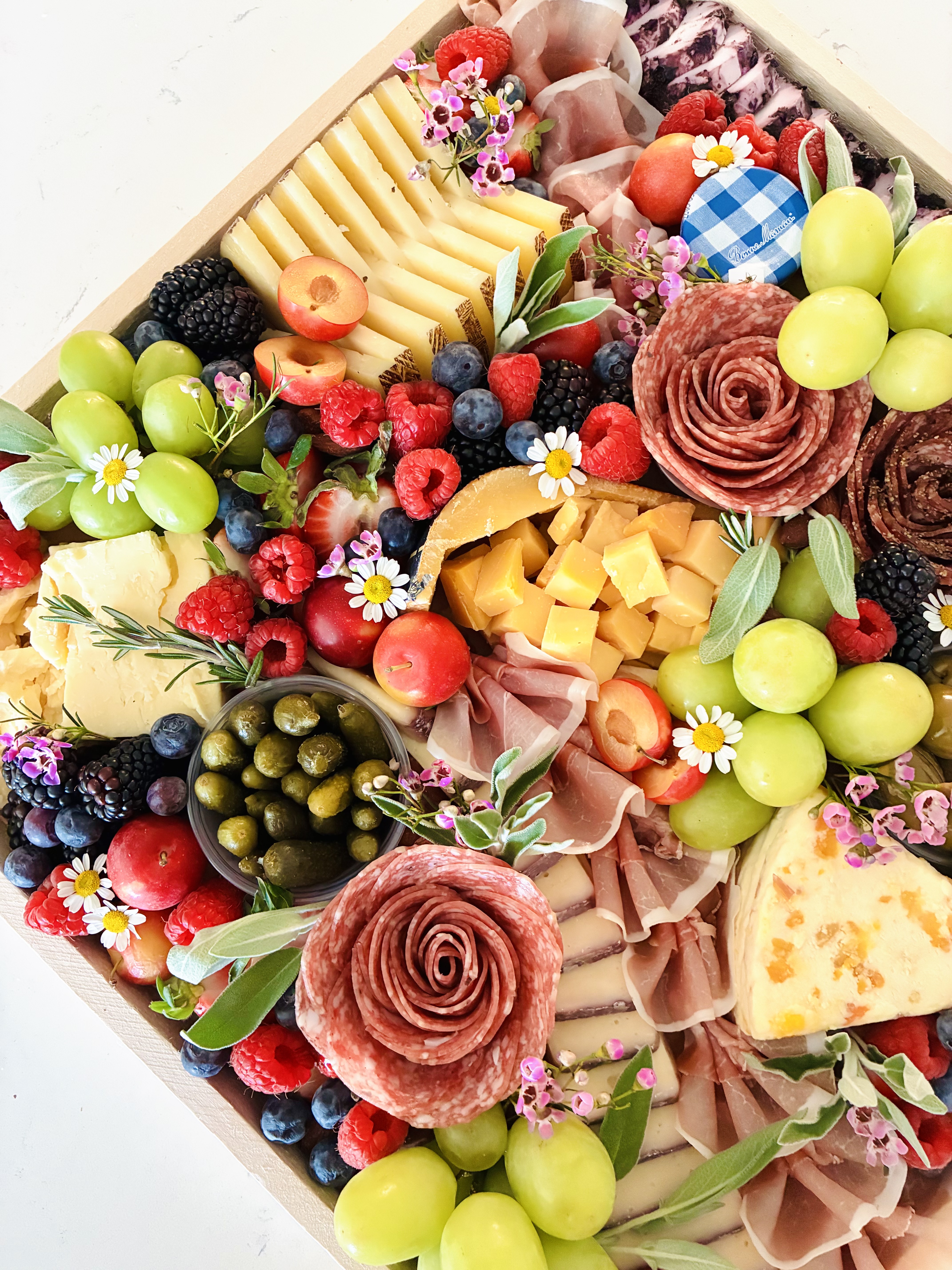 Luxury charcuterie board in Chicago featuring artisan cheeses, cured meats, seasonal fruit, and accompaniments on a 16x16 wood board, serving 15–20 as an appetizer