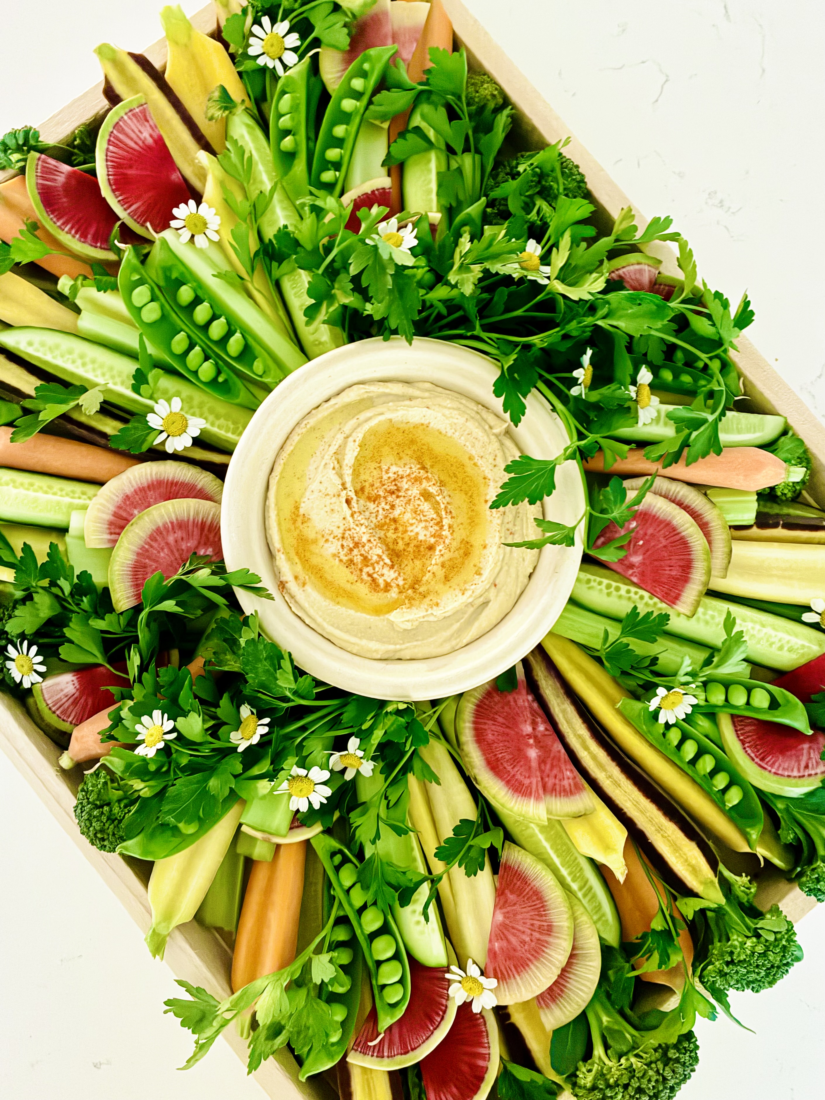 Elegant crudité board featuring a vibrant assortment of fresh seasonal vegetables with accompanying dips, thoughtfully styled for entertaining