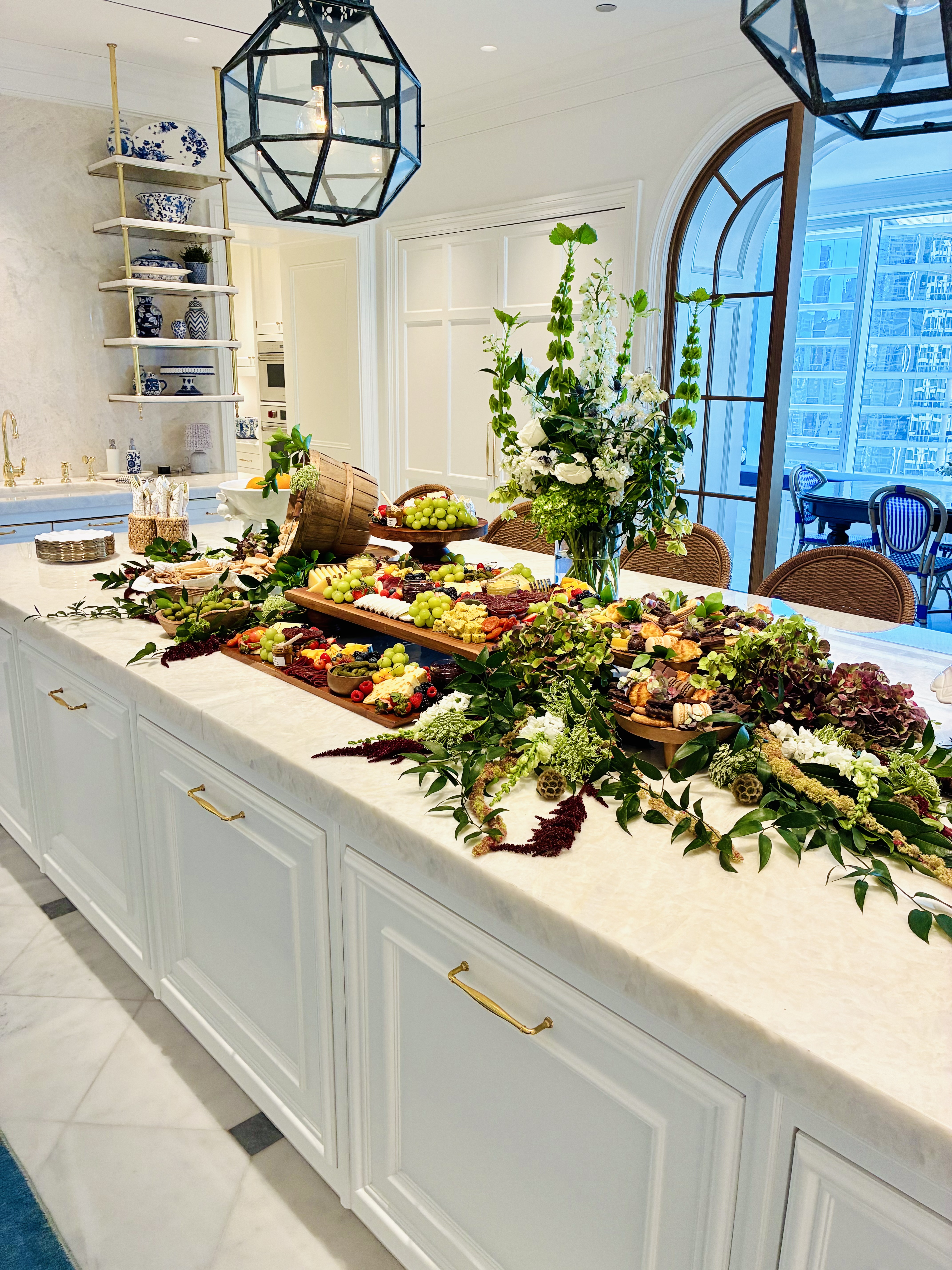 Luxury grazing table featuring artisanal cheeses, premium charcuterie, fresh fruit, wooden boards, lush greenery, and floral accents for a Chicago event.